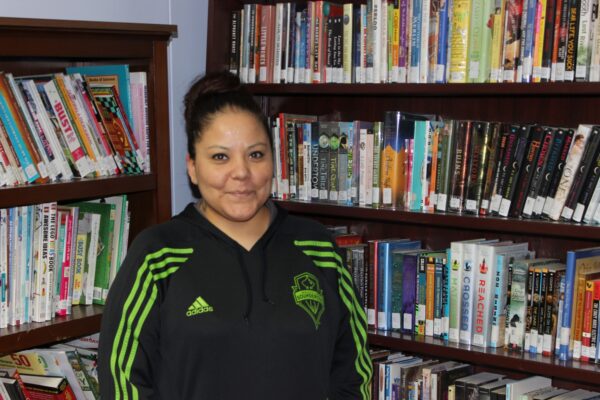 Leanna Haynes-Pierre in front of bookshelves in the library